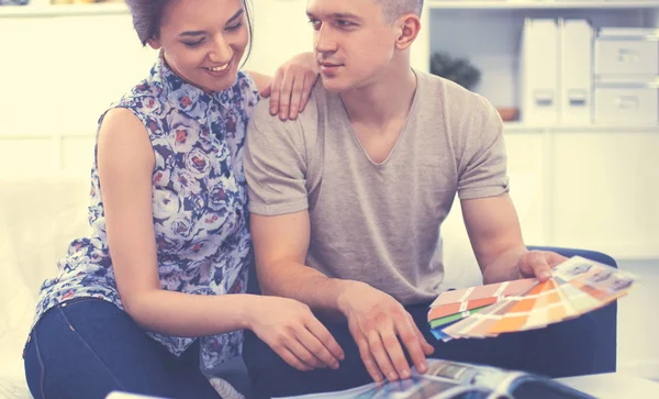 Feliz pareja joven sentados juntos en el sofá — Foto de Stock