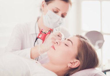 Kırmızı dudaklı genç bir kız kalıcı makyaj, mikro pigmentasyon