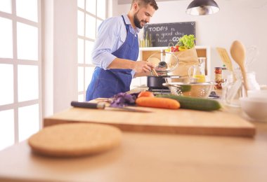 Adam ev mutfağında lezzetli ve sağlıklı yemekler hazırlıyor.