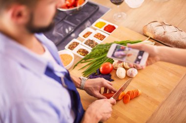 Adam ev mutfağında lezzetli ve sağlıklı yemekler hazırlıyor.