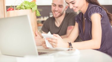 Çift evde mutfak içinde laptop ile onların fatura ödeme