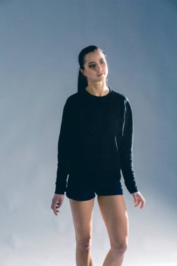 Gri arka planda izole edilmiş güzel ve sağlıklı bir spor kız portresi