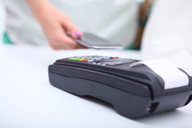 Müşteri ile smartphone Nfc teknolojisi kullanılarak dükkanda ödüyor. NFC teknolojisi. Müşteri ödeme