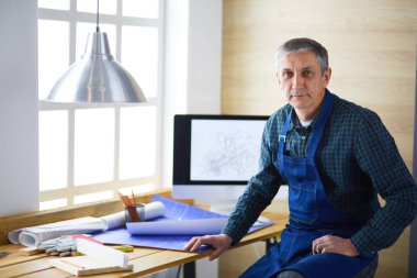 Ofisteki çizim masasında çalışan mimar