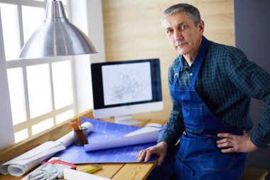 Ofisteki çizim masasında çalışan mimar