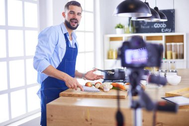 Mutfak arka planında poşet dolusu erzak tutan adam. Alışveriş ve sağlıklı gıda konsepti