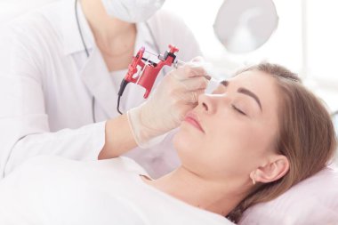 Kırmızı dudaklı genç bir kız kalıcı makyaj, mikro pigmentasyon