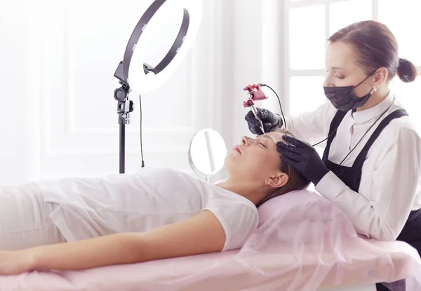 Microblading eyebrows work flow in a beauty salon. Woman having her eye brows tinted — Stock Photo, Image