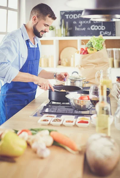 家のキッチンでおいしいと健康食品を準備する男 — ストック写真