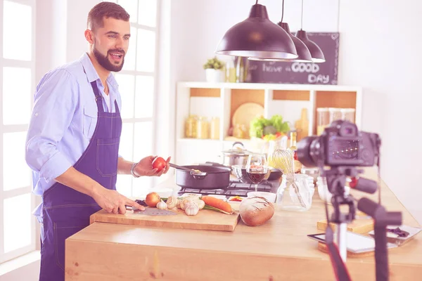 Man holding paper bag full of groceries on the kitchen background. Shopping and healthy food concept — Stock Photo, Image