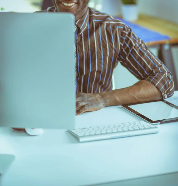 Stilig Afro amerikansk affärsman i klassisk kostym är att använda en laptop och leende medan arbetande i kontor — Stockfoto