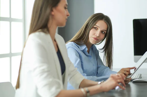 Zwei Bürokolleginnen sitzen auf dem Schreibtisch — Stockfoto