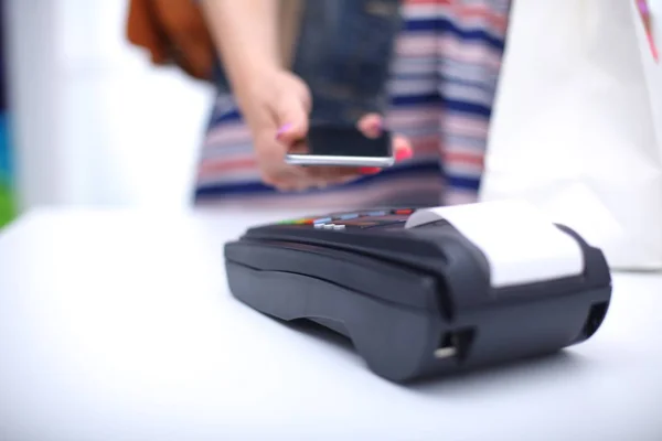 El cliente está pagando con el teléfono inteligente en la tienda utilizando la tecnología NFC. Tecnología NFC. Cliente está pagando —  Fotos de Stock
