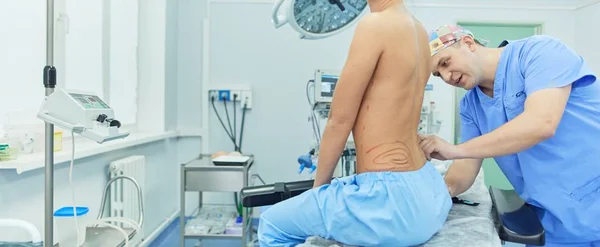 Médico mostrando al joven paciente su pecho en su consultorio en el hospital —  Fotos de Stock