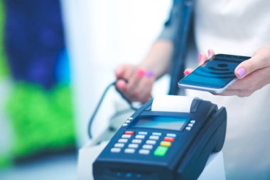 Müşteri ile smartphone Nfc teknolojisi kullanılarak dükkanda ödüyor. NFC teknolojisi. Müşteri ödeme