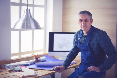 Ofisteki çizim masasında çalışan mimar