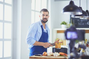 Mutfak arka planında poşet dolusu erzak tutan adam. Alışveriş ve sağlıklı gıda konsepti