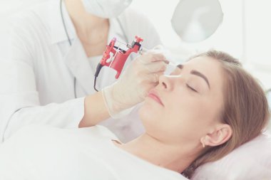 Kırmızı dudaklı genç bir kız kalıcı makyaj, mikro pigmentasyon