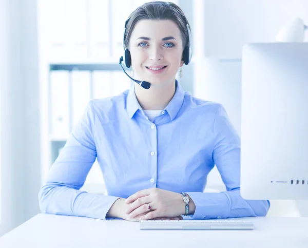 Seriös söt ung kvinna som arbetar som support telefonoperatör med headset i ämbetet — Stockfoto