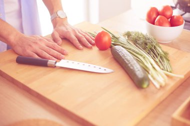 Adam ev mutfağında lezzetli ve sağlıklı yemekler hazırlıyor.