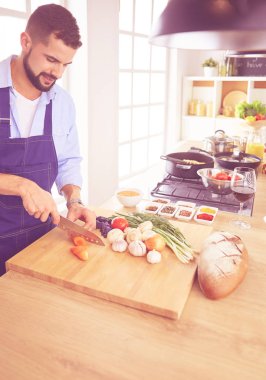 Adam ev mutfağında lezzetli ve sağlıklı yemekler hazırlıyor.