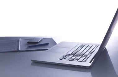 Kahve fincanı, dizüstü bilgisayar, dizüstü bilgisayar, gözlük ve hesap makinesi içeren ofis masası.