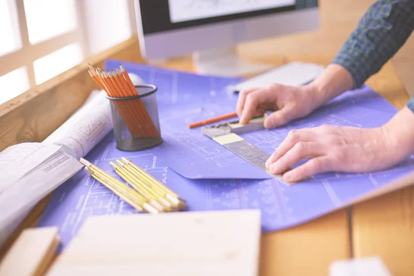 Arquitecto trabajando en mesa de dibujo en la oficina —  Fotos de Stock