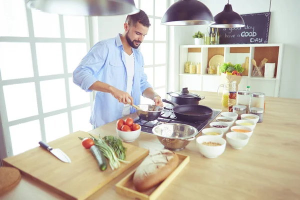 Чоловік готує смачну і здорову їжу на домашній кухні — стокове фото