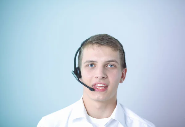 Retrato de un joven sonriendo sentado sobre un fondo gris. Retrato del joven — Foto de Stock