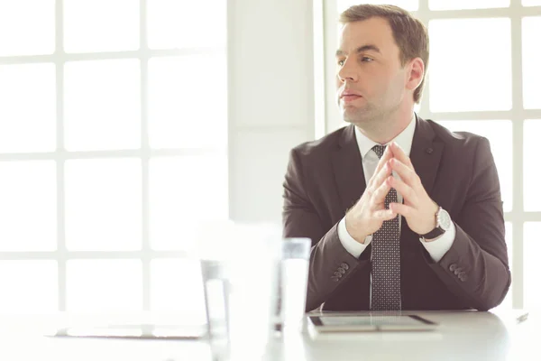 Portrait de jeune homme assis à son bureau dans le bureau. — Photo