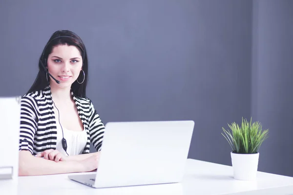 Бізнес-леді сидить на робочому столі в офісі використовуючи ноутбук носити гарнітуру — стокове фото