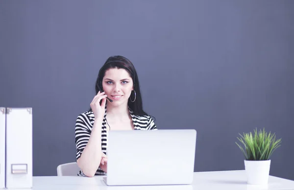Portret pięknej bizneswoman pracującej przy biurku ze słuchawkami i laptopem — Zdjęcie stockowe