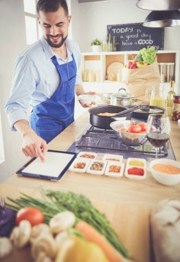 Adam ev mutfağında lezzetli ve sağlıklı yemekler hazırlıyor.