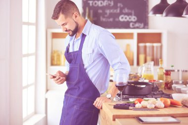 Mutfak arka planında poşet dolusu erzak tutan adam. Alışveriş ve sağlıklı gıda konsepti