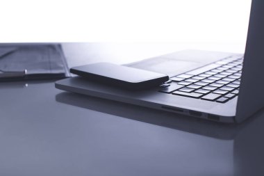 Dizüstü bilgisayar, klavye, akıllı telefon ve kalemiçeren ofis masası