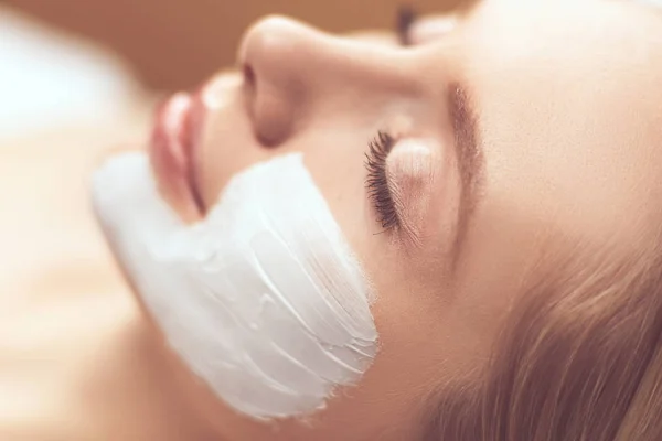 Jeune belle fille recevant un masque facial rose dans un salon de beauté spa — Photo