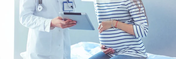 Hastanede doktorla gülümseyen güzel bir hamile kadın.