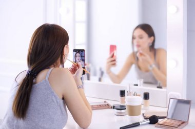 Ayna önünde akıllı telefon ile makyaj eğitimi filme Güzellik blogger