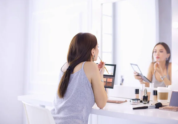 Brünette Frau beim Make-up für ein Date am Abend vor dem Spiegel — Stockfoto