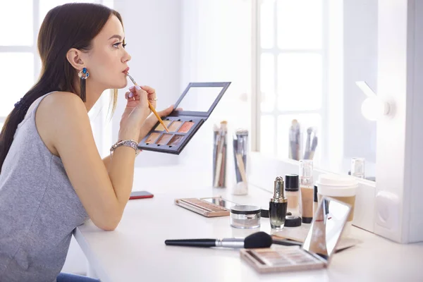 Brünette Frau beim Make-up für ein Date am Abend vor dem Spiegel — Stockfoto