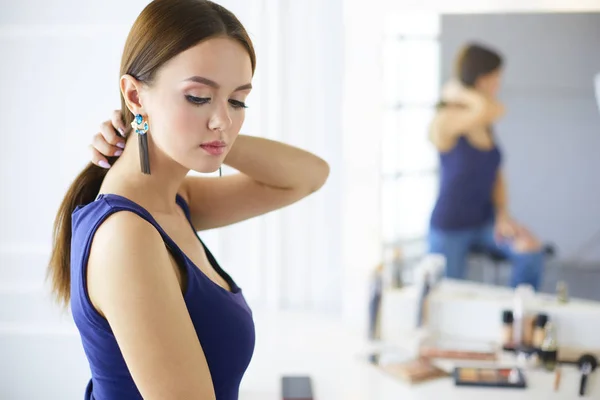 Vrouw staand met handen gevouwen in haar salon — Stockfoto