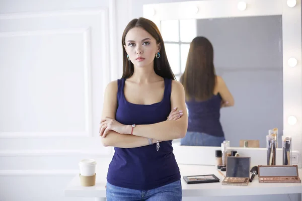 Mujer de pie con las manos dobladas en su salón — Foto de Stock