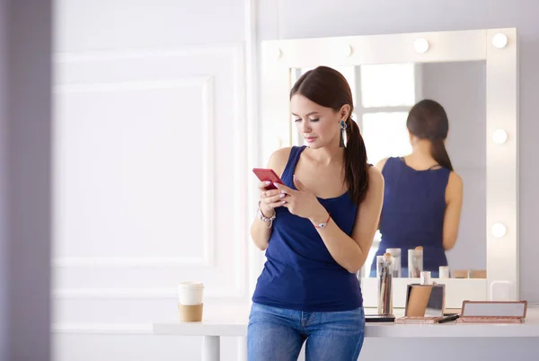 携帯電話を使って見ている女性美容院 — ストック写真