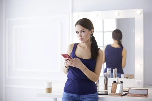 Kvinna skönhetssalong använda och titta på mobiltelefon — Stockfoto
