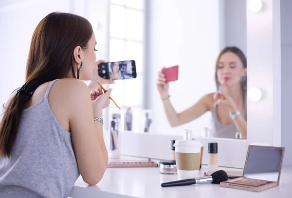 Beauty-Bloggerin filmt Make-up-Anleitung mit Smartphone vor Spiegel — Stockfoto