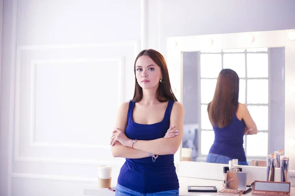 Mujer de pie con las manos dobladas en su salón —  Fotos de Stock