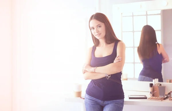 Mujer de pie con las manos dobladas en su salón —  Fotos de Stock