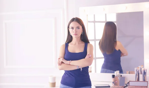 Vrouw staand met handen gevouwen in haar salon — Stockfoto