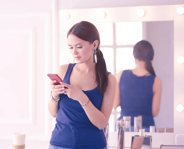 Жіночий салон краси використовує і дивиться на мобільний телефон — стокове фото