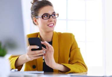 ofis telefon laptop ile oturuyor ve iş kadını